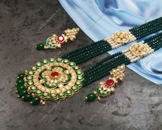 This is a stunning hand painted necklace perfect for high end Jewelry Collector, a keeper in Traditional Vintage Indian/Pakistani Bridal jewelry and a Luxury Gift for your Daughter, Sister or Wife on Wedding or Anniversary. Perfect for any type of occasions, weddings And celebrations and a beautiful & memorable gift for weddings and special occasions. -Item Code:- M214 -Rajwada Necklace Set with Earrings. -Designer multi layered Green beaded necklace with hand painted pendant. -Gold Plated Set with kundan which shine like precious stones. -Metal: Gold plated brass -Earrings are 68mm long & 22mm wide approx -Push Back Earrings -Necklace length with pendant 12" approx excluding adjustable dori/cord -Quantity:- One Necklace Set Please see more different designs here:- https://www.etsy.com/in- Traditional Hand Painted Round Beads Jewelry, Green Jewelry For Marriage And Festivals, Traditional Green Necklaces For Marriage, Traditional White Hand Painted Jewelry, Hand Painted Necklaces For Festivals, Traditional Hand Painted Festive Necklaces, Hand Painted Festive Necklace, Traditional Beaded Necklaces For Marriage, Traditional Green Kundan Necklace For Marriage