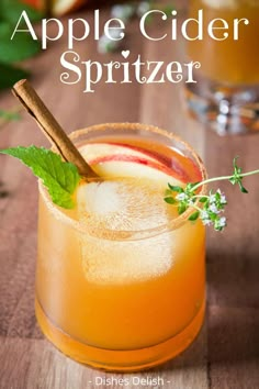 an apple cider spritzer is garnished with mint