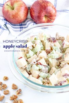 an apple salad in a glass bowl next to two apples