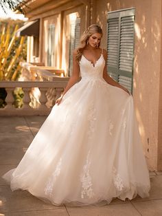 a woman in a wedding dress standing outside