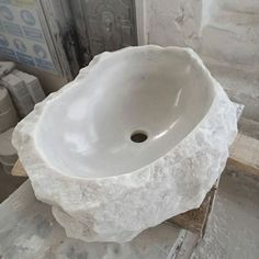 a white sink sitting on top of a marble slab