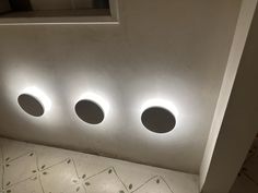 three round lights are on the side of a wall