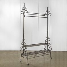 a wrought iron shelf with two shelves on each side and an open door in the background