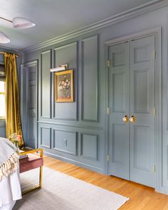 a bedroom with blue walls and wooden floors