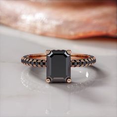 a black diamond ring on a white surface