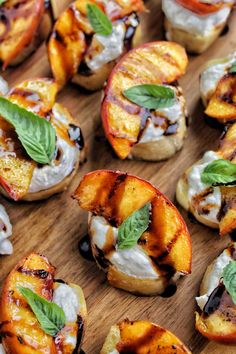 grilled peaches with whipped cream and fresh basil on a wooden cutting board, ready to be eaten