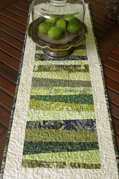 a table runner with limes in a bowl on it