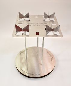 a metal stand with four different types of bow ties on it's top and bottom