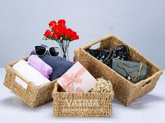 two wicker baskets with towels, sunglasses and flowers in them on a white surface