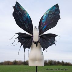 a black and blue butterfly wings on a mannequin head