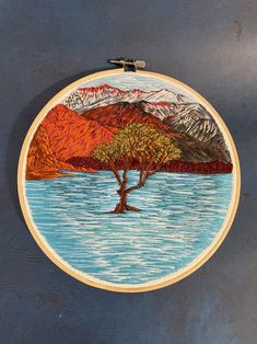 a painting of a tree on the side of a wall with mountains in the background