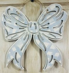 a white butterfly shaped door hanger on a wooden door