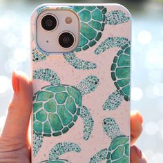 a person holding an iphone case with sea turtles on it