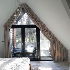 a bedroom with an open window and sliding glass doors