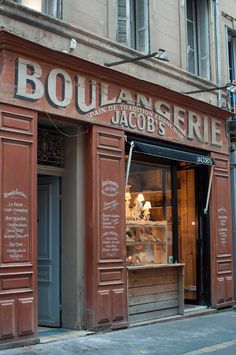 the outside of a restaurant with chalk writing on it's front door and windows