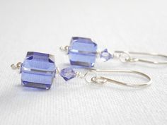 These lavender cube earrings feature Swarovski Crystals in Tanzanite.  Each Swarovski crystal cube is topped with a silver spacer bead and another small crystal.  The tanzanite purple beaded drop earrings dangle from sterling silver earring wires.  The last photo shows the earrings in Fuchsia (sold separately).  Other colors are available in my shop. Swarovski cube crystals measure 8mm.  Small crystals are 4mm.  Silver plated beads.  Sterling silver ball headpins and earring wires. Total length: Cube Earrings, Purple Beaded, Swarovski Crystal Jewelry, Beads Bracelet Design, Earrings Purple, Beaded Drop Earrings, Silver Dangle Earrings, Swarovski Crystal Earrings, Swarovski Earrings