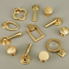 a collection of golden door handles and knobs on a gray surface with white background