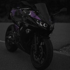 a black and purple motorcycle parked on the street