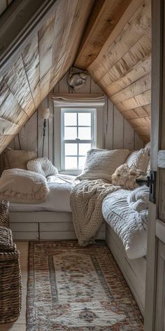 an attic bedroom with wooden walls and white bedding, rugs on the floor