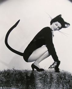 a black and white photo of a woman with a cat costume