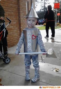 a little boy dressed up as a tin man with a heart on it's chest