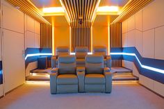 a room with two recliners and some lights on the wall behind them,