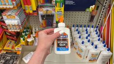 a person is holding a bottle of school glue