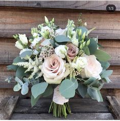 a bouquet of flowers sitting on top of a wooden bench