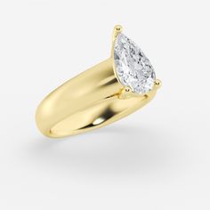 a yellow gold ring with a pear shaped diamond in the center, on a white background