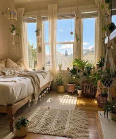 a bed room with a neatly made bed and lots of plants on the windowsill