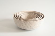 four white bowls stacked on top of each other