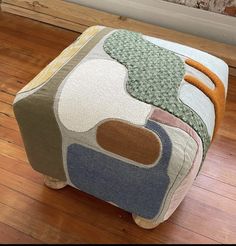 a patchwork footstool is sitting on the floor