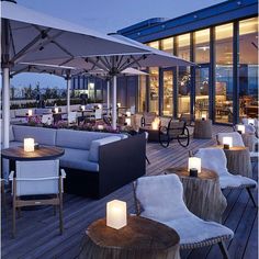 an outdoor seating area with lit candles on the tables