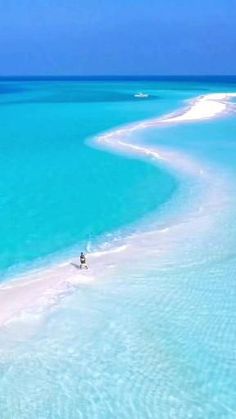 the water is crystal blue and clear with white sand on both sides, as well as an island in the middle