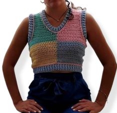 a woman with her hands on her hips wearing overalls and a crochet top