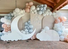 a baby shower is decorated with balloons and clouds