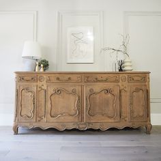 a large wooden dresser sitting next to a lamp