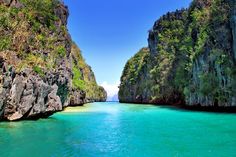 the water is crystal blue and green in this photo, with cliffs on either side