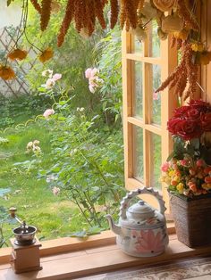 a window sill filled with flowers next to a potted plant