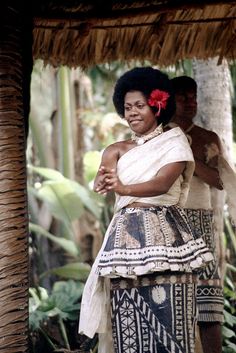 a woman standing next to a man in front of palm trees