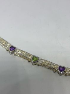 This Peridot and Amethyst bracelet is very lively and bright. The stones are deep colors and well matched. The sterling silver is plated with rhodium to protect the bracelet from tarnish and give the appearance of white gold. 7.5 inches Can be sized down by my jeweler for a $10 fee. All jewelry is shipped in a nice gift box. Check out our over a THOUSAND great reviews Engraving is $4 per letter and is not always perfect depending on the piece. It can take a few days if the jeweler is busy. This Sterling Silver Multi-stone Bracelets, Sterling Silver Multicolor Bracelets For Anniversary, Multicolor Sterling Silver Bracelet For Anniversary, Multicolor Sterling Silver Anniversary Bracelet, White Gold Multi-stone Bracelets As Gift, White Gold Multi-stone Bracelet For Gift, Sterling Silver Bracelets With Gemstone Accents For Anniversary, Sterling Silver Bracelet With Gemstone Accents, Purple Gemstone Sterling Silver Bracelet For Anniversary