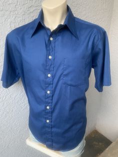 "This deep blue, genuine 1970s vintage, short sleeve, butterfly collared shirt is in excellent vintage condition. SIZE: Pit to Pit: 25\" Collar to hem: 31\" Sleeves: 11\" The tag does not have a size. Check the measurements. I would say it fits like a roomy XL The male mannequin would be 5'10\" 170 lbs. ITEM 125" Blue Cotton Johnny Collar Short Sleeve Shirt, Blue Cotton Short Sleeve Johnny Collar Shirt, Blue Cotton Short Sleeve Shirt With Johnny Collar, Blue Cotton Johnny Collar Shirt, Blue Cotton Shirt With Johnny Collar, Blue Cotton Johnny Collar Camp Shirt, Blue Cotton Camp Shirt With Johnny Collar, Fitted Blue Short Sleeve Shirt For Summer, Blue Fitted Short Sleeve Shirt For Summer