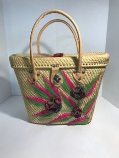 "Vintage 1960s straw handbag purse tote, Vintage embroidered straw handbag tote with applied floral detail. Large straw tote Applied 3-dimensional straw floral details (A couple of the threads are disconnected) Vibrant pink/green embroidered design on front/top of tote Natural leather straps/closure (leather feels/looks like genuine but not 100% sure) Great vintage condition overall Height 10\" Width 14\" Depth 4\" Handles 17\"" Handmade Vintage Natural Straw Bag, Vintage Natural Straw Bag, Handmade Vintage Straw Bag, Vintage Straw Bag With Bamboo Handle, Vintage Handmade Straw Bag For Daily Use, Vintage Natural Straw Bag With Handles, Vintage Straw Bag For Summer Vacation, Vintage Summer Straw Bag For Vacation, Vintage Handwoven Straw Bag For Beach