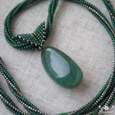 This boho jade pendant necklace is made with Japanese Toho seed bead and drop nephrite. This large jade pendant on hand woven bead necklace is a nice gift for women any occasion. Properties of balance stone used in boho necklace: Jade: This stone has powerful effects on heart chakra and love. It helps to stop inner sabotage and also it makes stronger the feelings of self love and self worth. It also helps to be calm and peaceful. Length of beaded rope necklace is approx. 60 cm (23.62 inch). Size of drop nephrite pendant with beaded bale is approx. 50 mm (1.97 inch) x 18 mm (0.71 inch). Size of drop nephrite: 35 mm (1.38 inch) x 18 mm (0.71 inch). Your large jade necklace will be wrapped up in a beautiful organza bag and craft box. Thank you very much for purchasing and visiting my shop! Adjustable Beaded Necklace With Teardrop Pendant, Bohemian Beaded Necklaces With Teardrop Natural Stones, Artisan Beaded Teardrop Necklaces, Spiritual Teardrop Beaded Necklaces For Jewelry Making, Handmade Spiritual Teardrop Drop Necklace, Artisan Teardrop Beaded Necklace, Handmade Adjustable Beaded Necklace With Teardrop Pendant, Handmade Adjustable Teardrop Pendant Beaded Necklaces, Handmade Adjustable Teardrop Pendant Beaded Necklace