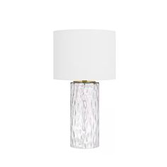 a clear glass table lamp with a white shade