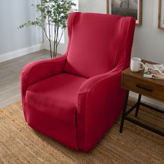 a red recliner chair sitting on top of a rug next to a wooden table