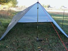 a white tent sitting on top of a lush green field