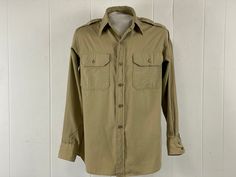 "Vintage 1940s work shirt, WWII U.S. Army military shirt. Made of khaki cotton poplin. Has two chest pockets, shoulder epaulets, side gussets, button down front, and button cuffs. No label, About a size medium.  Actual measurements are:   46\" at the chest   43\" at the waist   17\" shoulder seam to shoulder seam  23\" shoulder seam to cuff  29\" overall length  In very good condition with two pin holes on left shoulder, see picture." Khaki Collared Utility Shirt, Khaki Collared Military Shirt, Khaki Military Collared Shirt, Vintage Collared Khaki Shirt, Vintage Khaki Shirt With Pockets, Vintage Khaki Button-up Shirt, Army Shirt, Military Shirt, Khaki Shirt