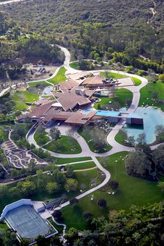 an aerial view of a large estate surrounded by trees and water features swimming pool, hot tub, tennis court and spa