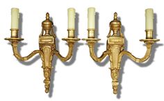 three gold - plated candelabra with candles on each arm